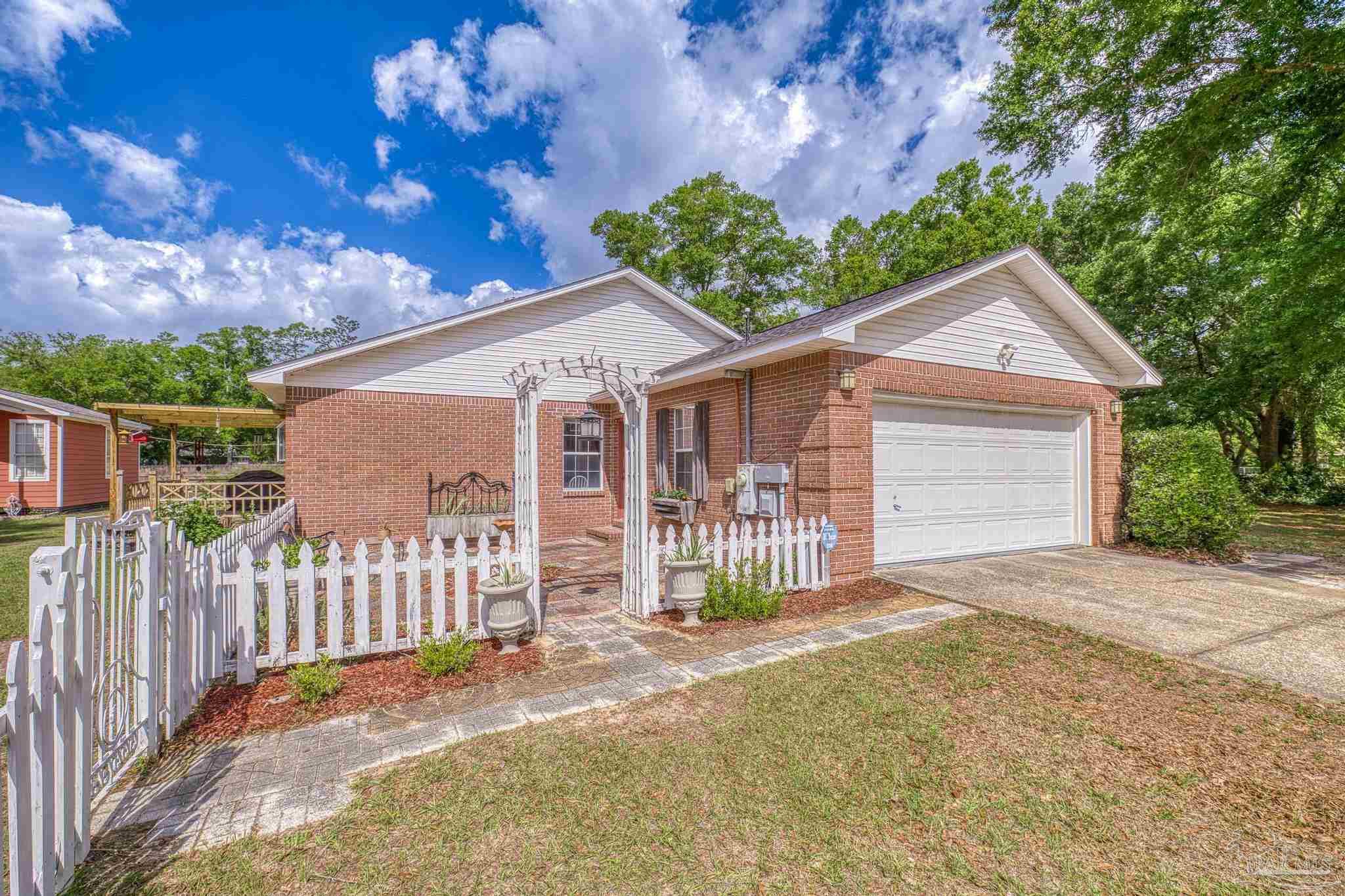 4959 Skipper Lane Pace, FL 32571 - Photo 33 of 51 a front view of a house with a garden