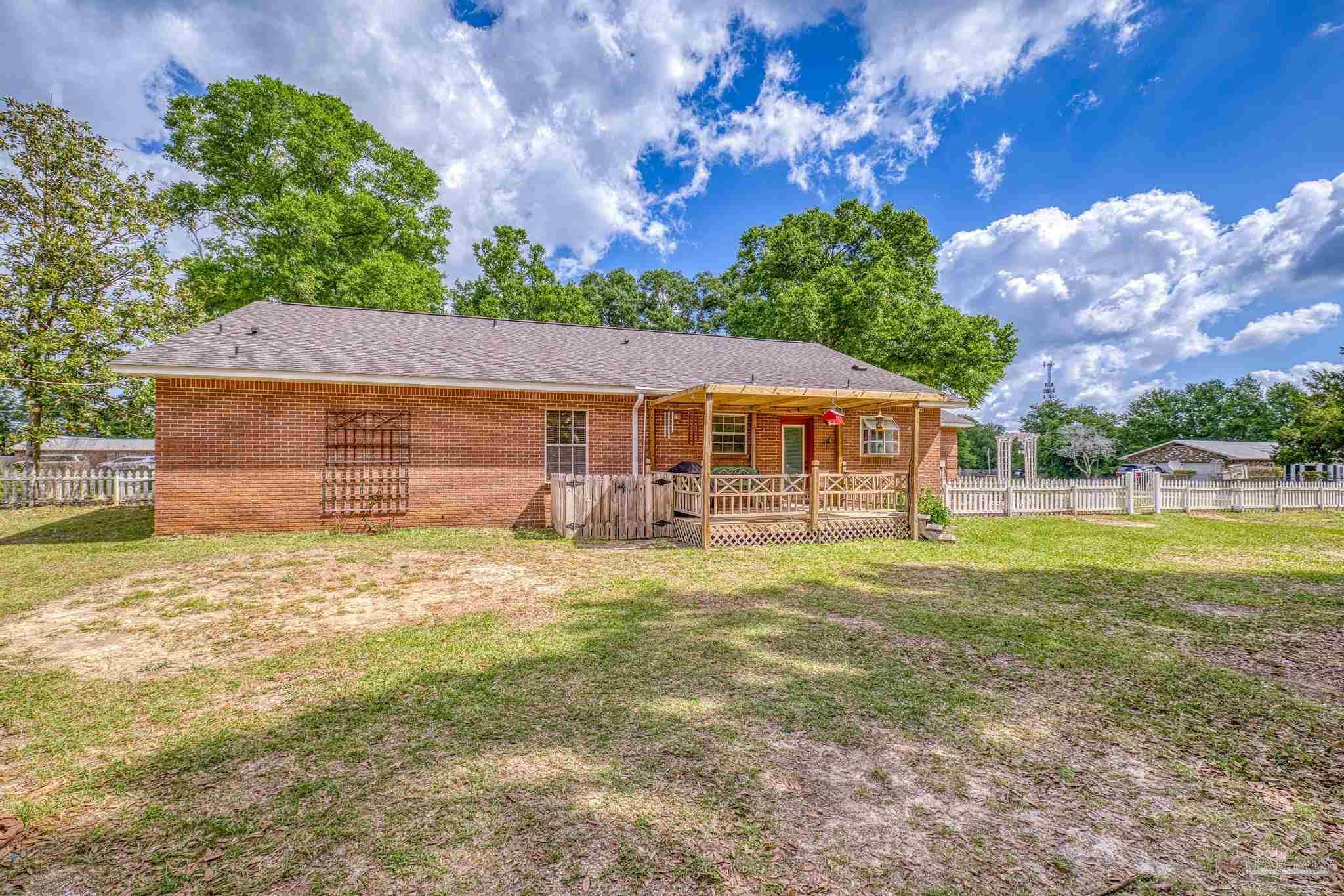 4959 Skipper Lane Pace, FL 32571 - Photo 35 of 51 a backyard of a house with table and chairs