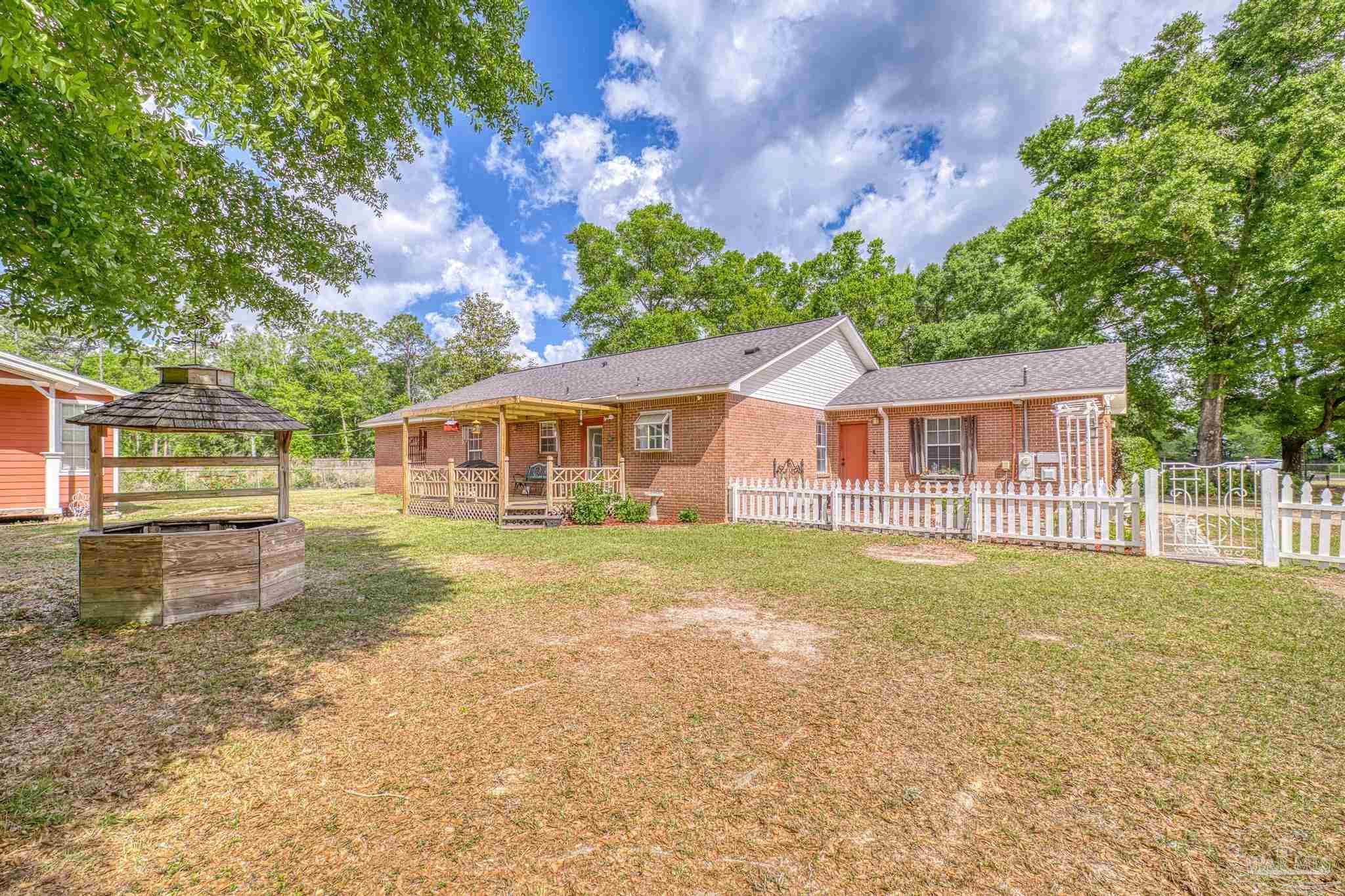 4959 Skipper Lane Pace, FL 32571 - Photo 36 of 51 a front view of a house with a garden