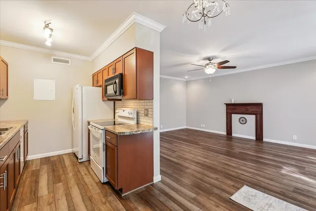 a kitchen center island wooden floor and stainless steel appliances