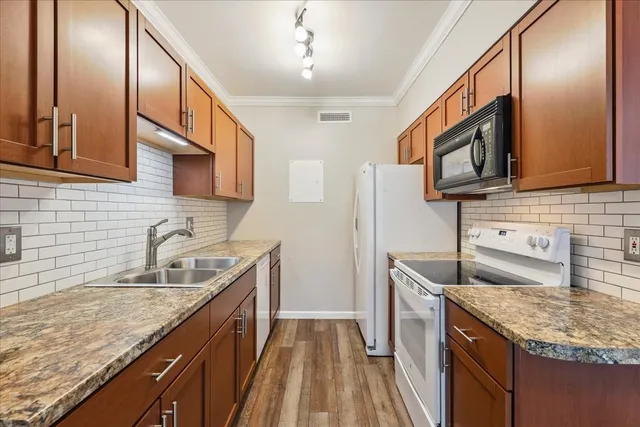 a kitchen with granite countertop stainless steel appliances microwave sink and stove