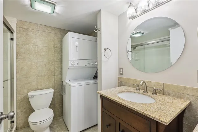 a bathroom with a granite countertop toilet sink and mirror