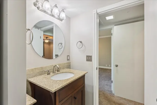 a bathroom with a granite countertop sink and a mirror