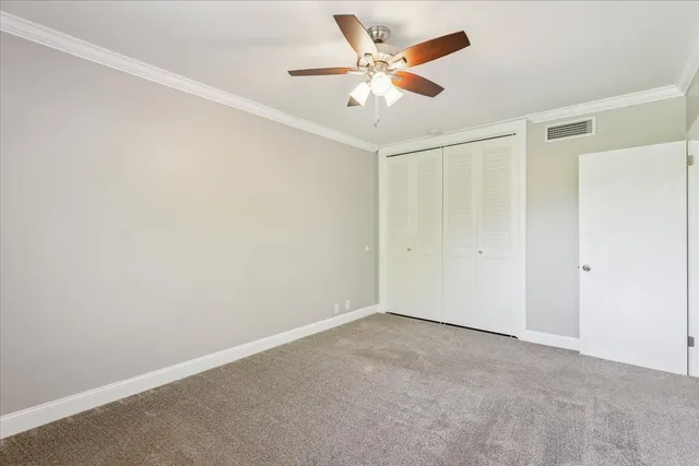 an empty room with a ceiling fan and a window