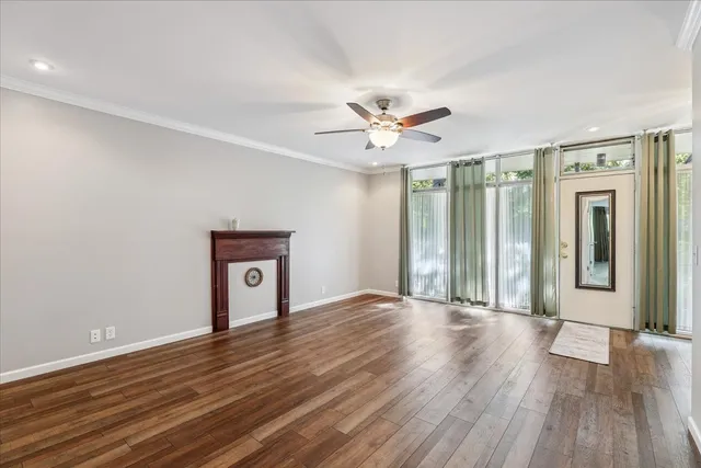 a view of a big room with wooden floor and a ceiling fan