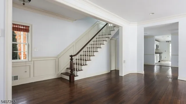 a view of an entryway with wooden floor and stairs