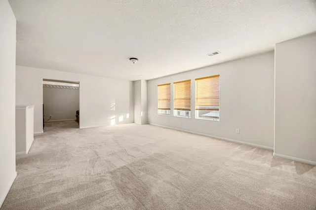 an empty room with windows and closet