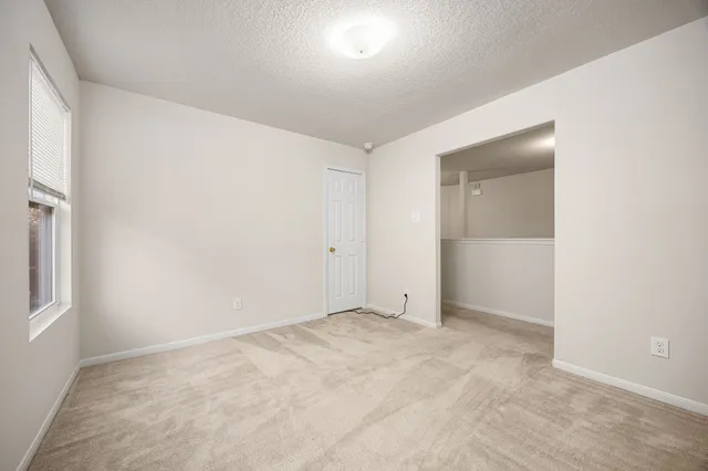 an empty room with fan and windows