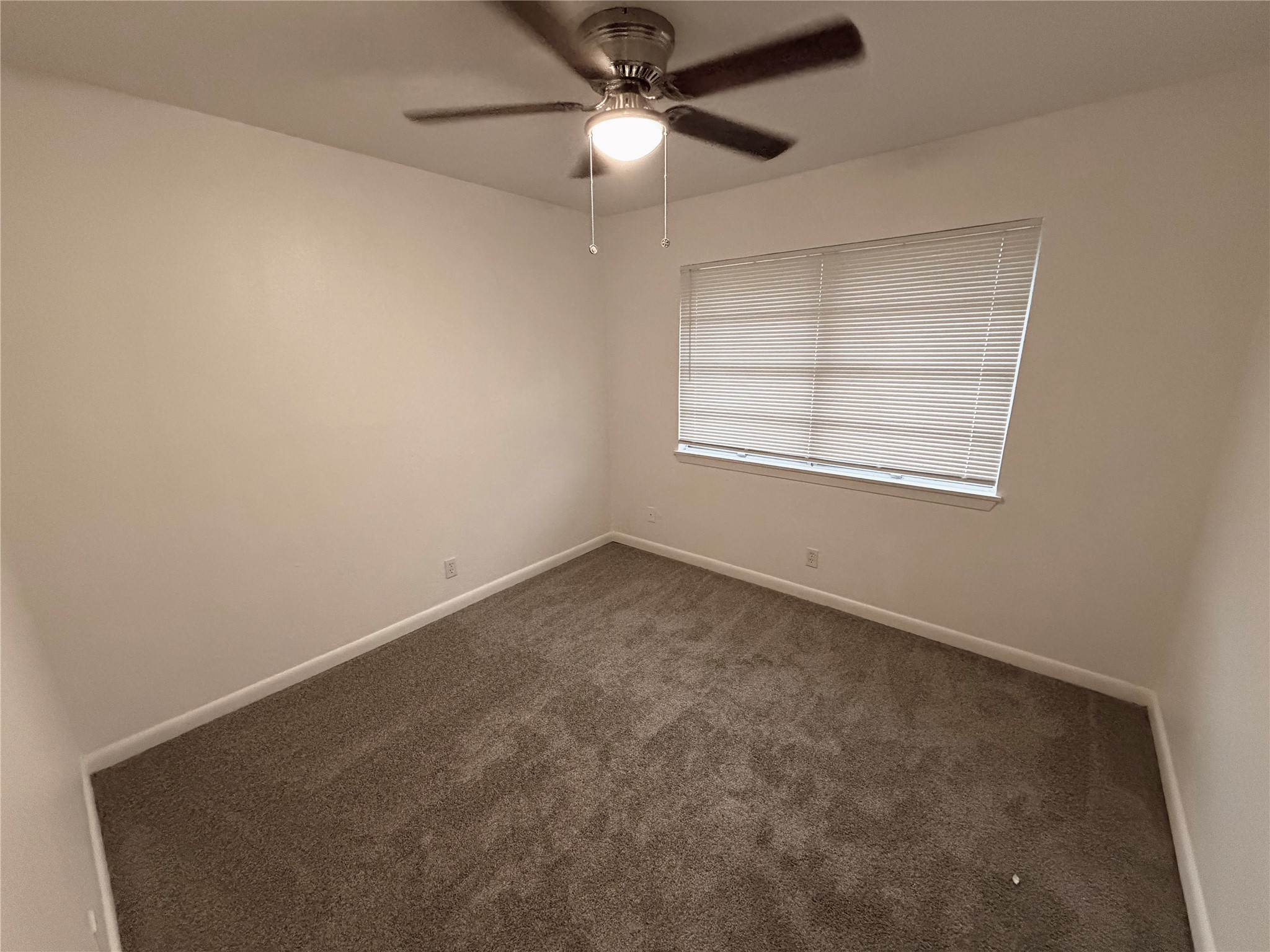 316 Angle Street Angleton, TX 77515 - Photo 23 of 30 an empty room with a window and a fan