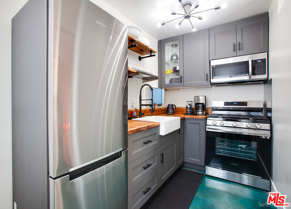 2912 11th Street, Unit 4 Santa Monica, CA 90405 - Photo 6 of 39 a kitchen with stainless steel appliances granite countertop a refrigerator a stove top oven a sink and dishwasher