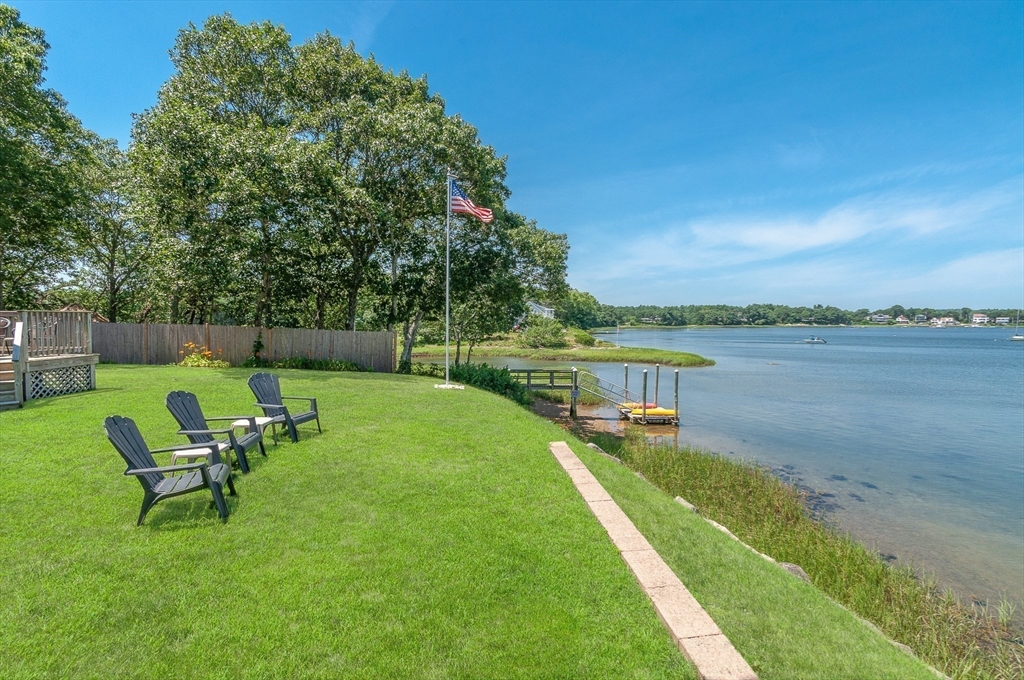 27 Over Jordan Road Wareham, MA 02571 - Photo 10 of 28 a view of a lake with a garden and a bench