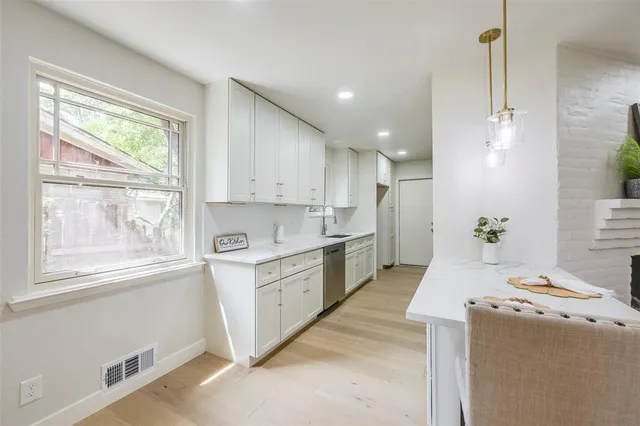 a kitchen with granite countertop white cabinets and white appliances
