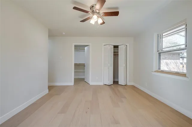 a view of a big room with wooden floor and windows