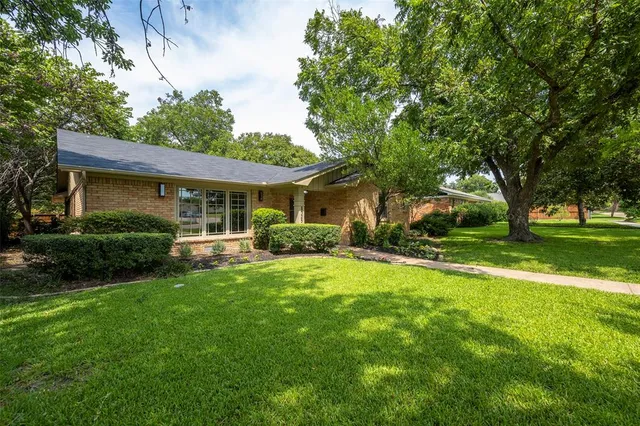 a front view of a house with yard patio and green space