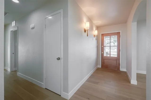 a view of hallway with windows and wooden floor