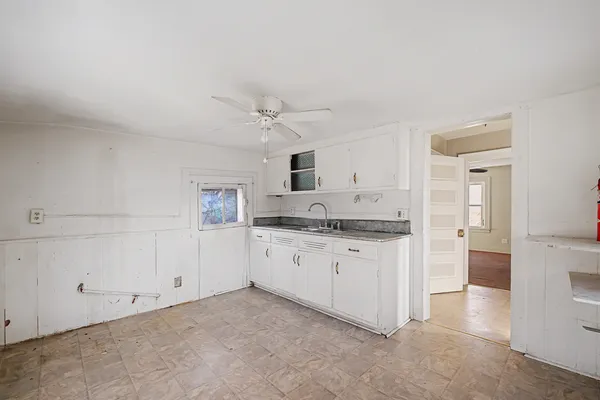 a kitchen with granite countertop white cabinets and white appliances