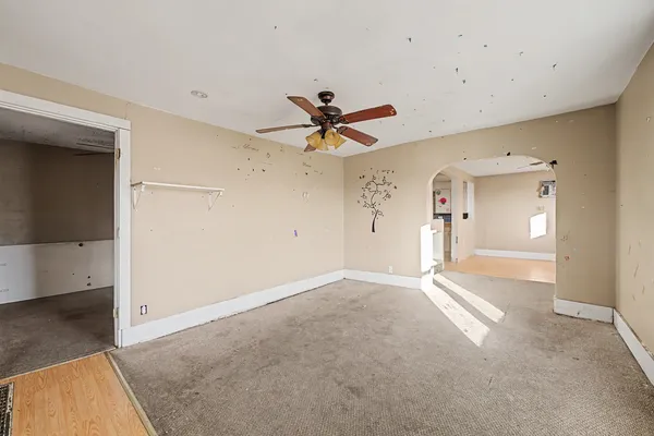 wooden floor in an empty room with a ceiling fan