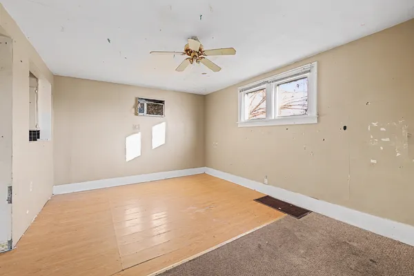 an empty room with windows and fan