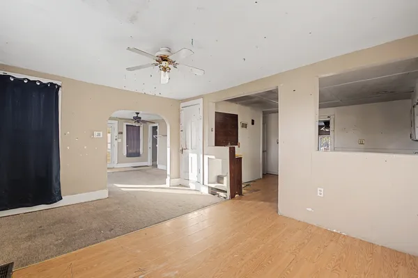 a view of a livingroom with a furniture ceiling fan and window