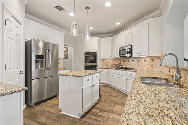 a kitchen with stainless steel appliances granite countertop a refrigerator sink and cabinets