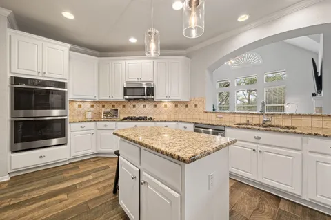 a kitchen with stainless steel appliances granite countertop a sink stove and microwave
