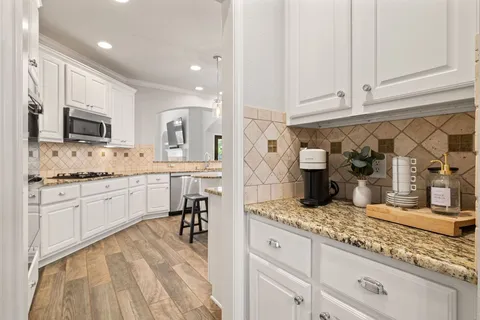 a kitchen with granite countertop a sink appliances cabinets and counter space