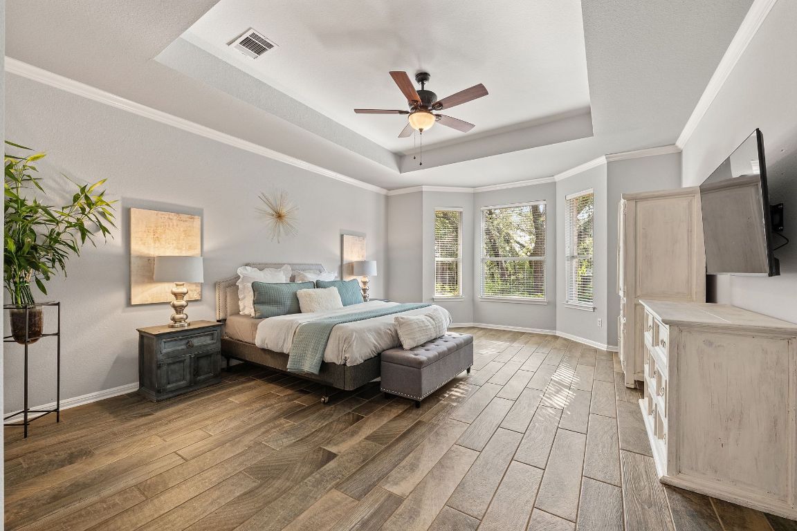 3209 Indigo Waters Drive Austin, TX 78732 - Photo 17 of 40 a spacious bedroom with a bed and a flat screen television