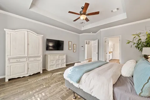 a spacious bedroom with a bed and a flat screen tv