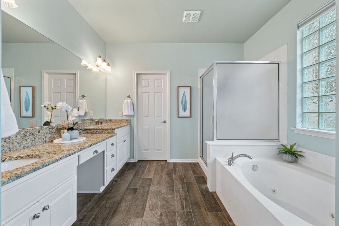 3209 Indigo Waters Drive Austin, TX 78732 - Photo 19 of 40 a spacious bathroom with a granite countertop tub sink shower and mirror