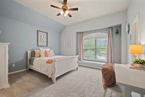 a bedroom with a bed lamp and a large window