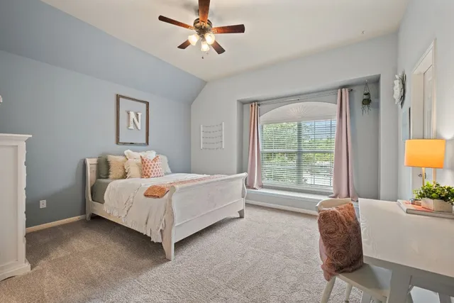 a bedroom with a bed lamp and a large window