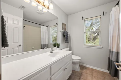 a bathroom with a double vanity sink toilet and a mirror