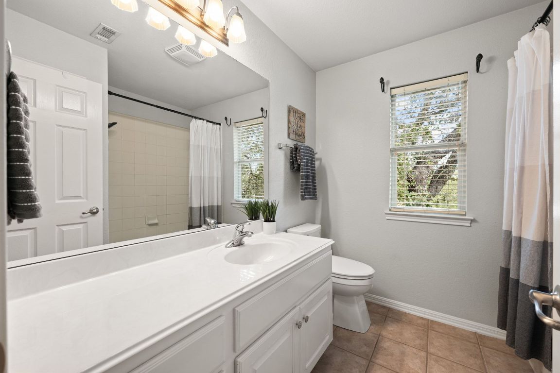 3209 Indigo Waters Drive Austin, TX 78732 - Photo 28 of 40 a bathroom with a double vanity sink toilet and a mirror