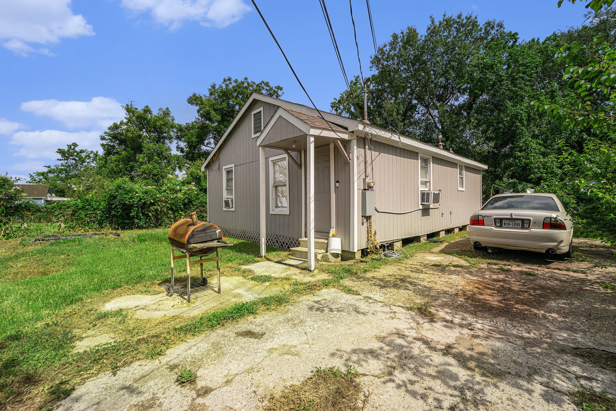 5105 Earline Street Houston, TX 77016 - Photo 6 of 8 a white house covered with tall trees