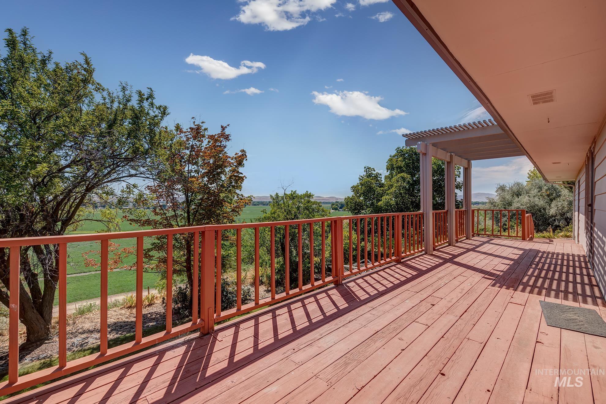 1493 Cove Road Weiser, ID 83672 - Photo 20 of 50 Expansive wood-plank deck with a perimeter railing and covered patio area