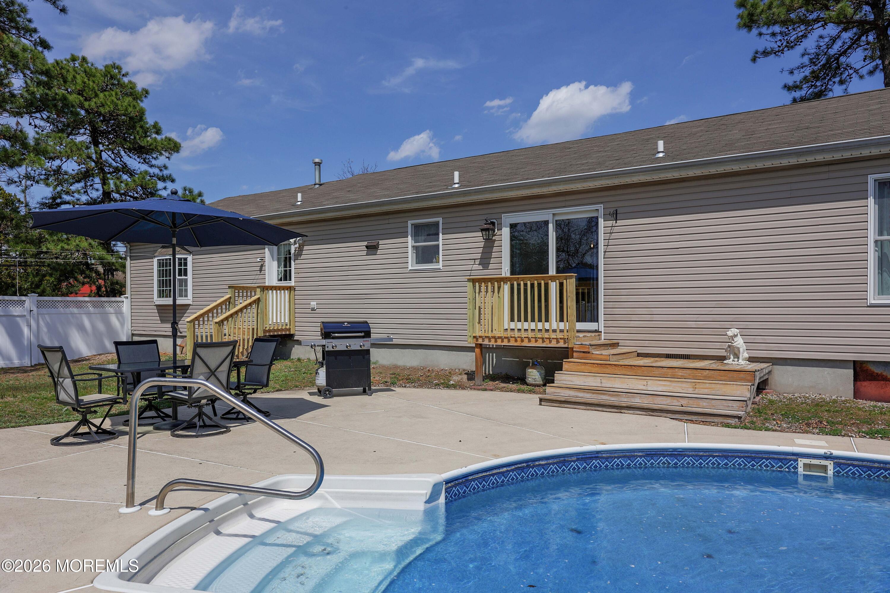 96 Atrium Drive Brick, NJ 08723 - Photo 26 of 39 a view of a patio with table and chairs under an umbrella