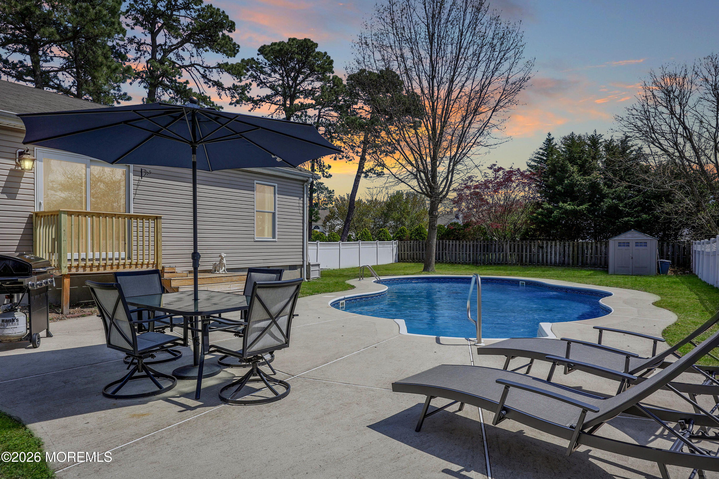 96 Atrium Drive Brick, NJ 08723 - Photo 3 of 39 a patio with a table and chairs under an umbrella