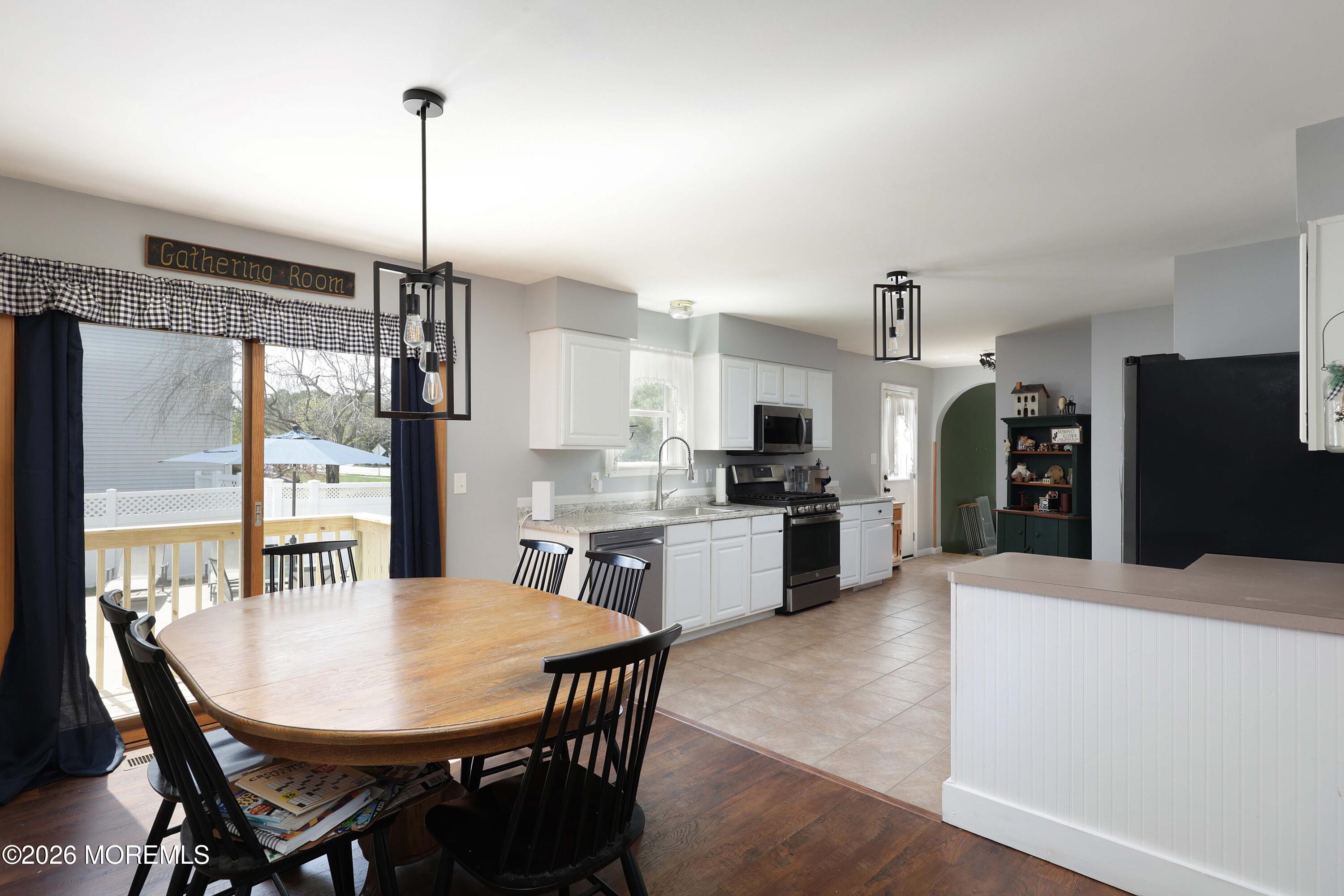 96 Atrium Drive Brick, NJ 08723 - Photo 8 of 39 a kitchen with stainless steel appliances kitchen island granite countertop a refrigerator a kitchen island a stove a dining table and chairs
