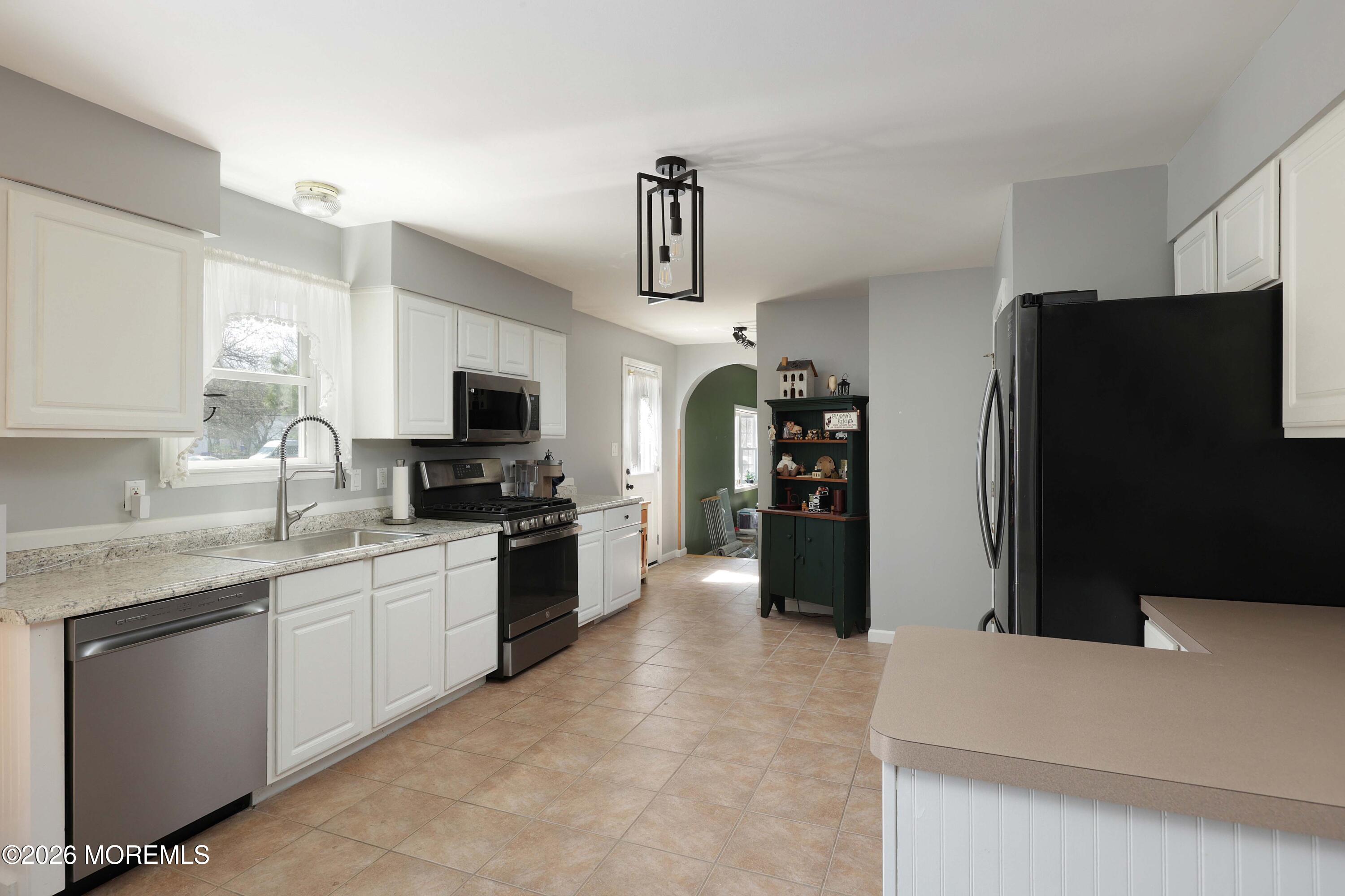96 Atrium Drive Brick, NJ 08723 - Photo 10 of 39 a kitchen with stainless steel appliances a refrigerator sink and stove
