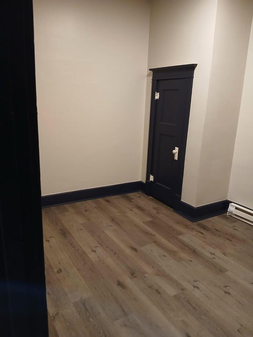 1818 4th Street, Unit 2 Peru, IL 61354 - Photo 11 of 13 an empty room with wooden floor and cabinet