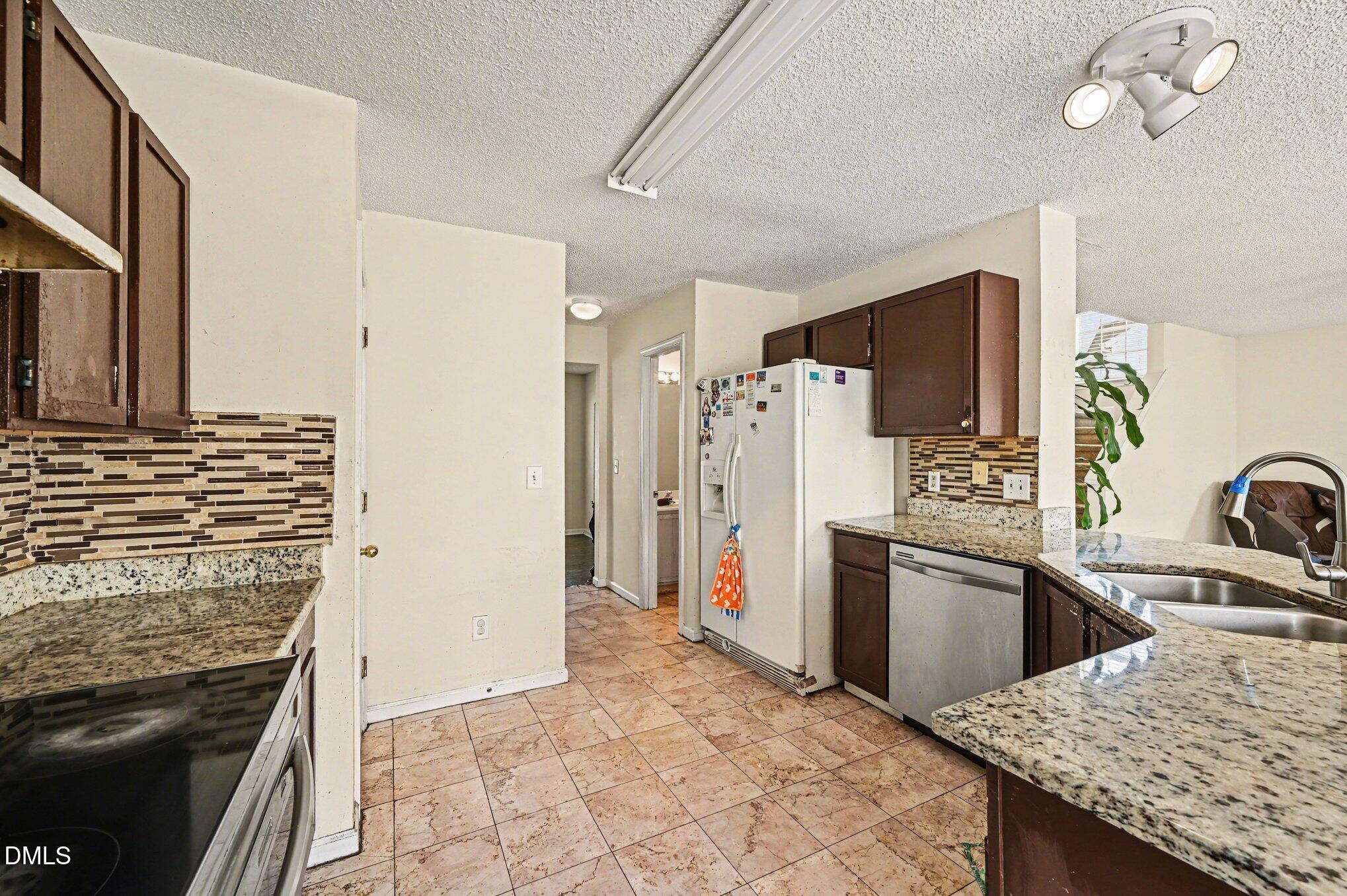5115 Cardinal Grove Boulevard Raleigh, NC 27616 - Photo 6 of 36 a kitchen with refrigerator a stove and a sink