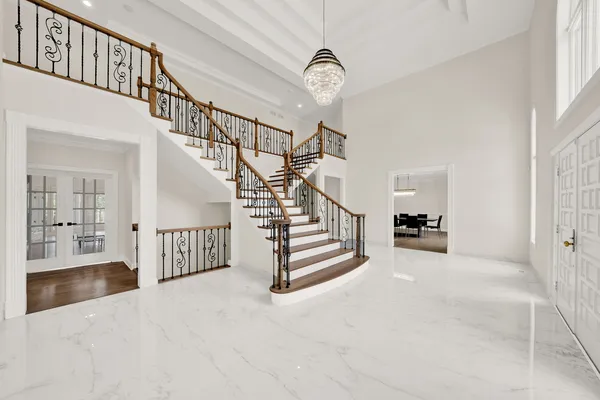 a kitchen with stainless steel appliances granite countertop a stove a sink a refrigerator and white cabinets with wooden floor