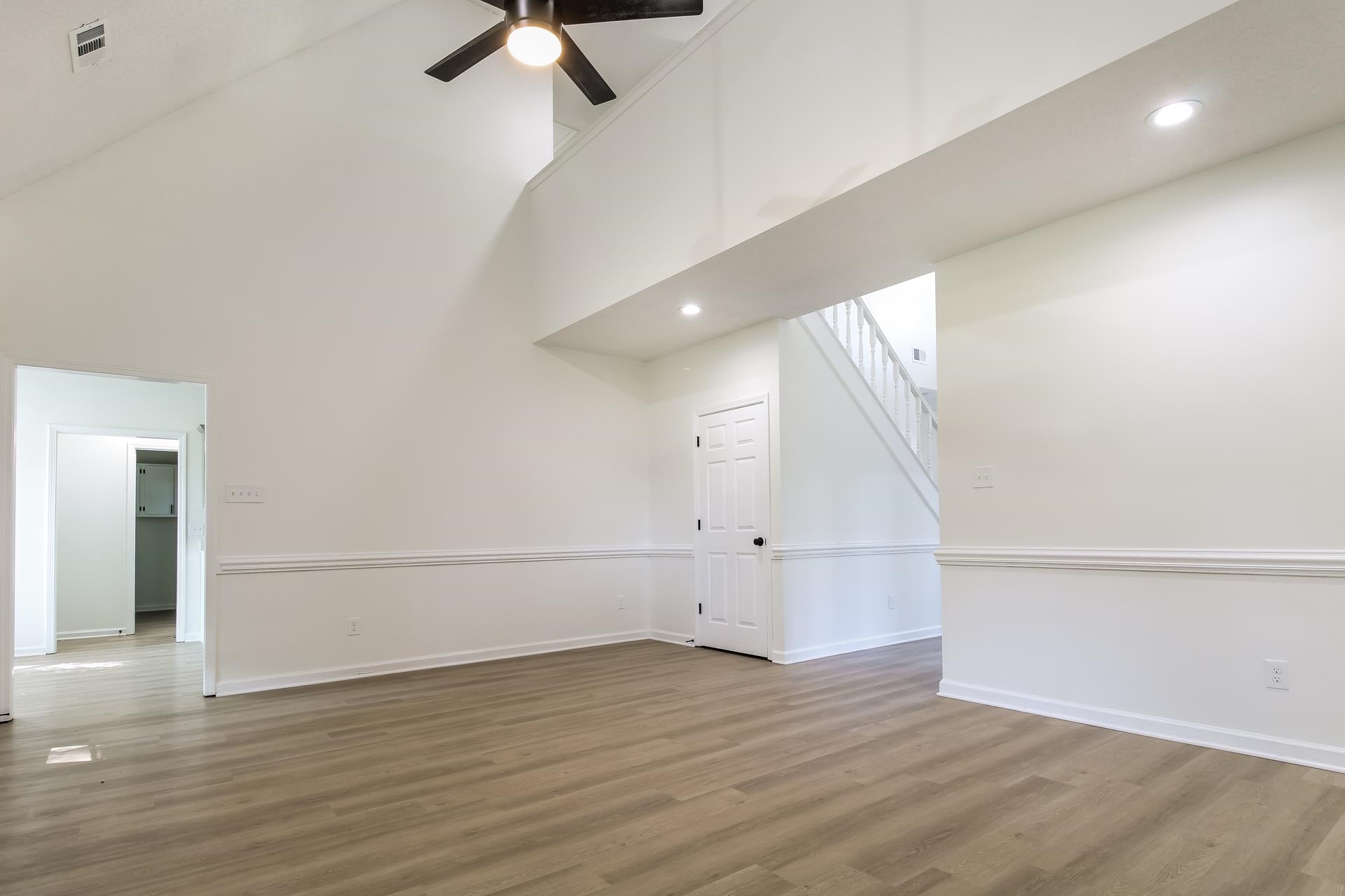 Bonus room featuring light wood finished floors, high vaulted ceiling, ceiling fan, recessed lighting, and stairs