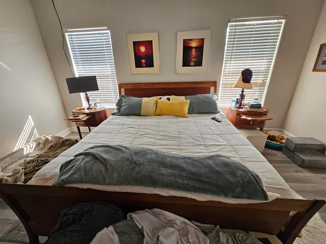 a bedroom with a bed and wooden floor