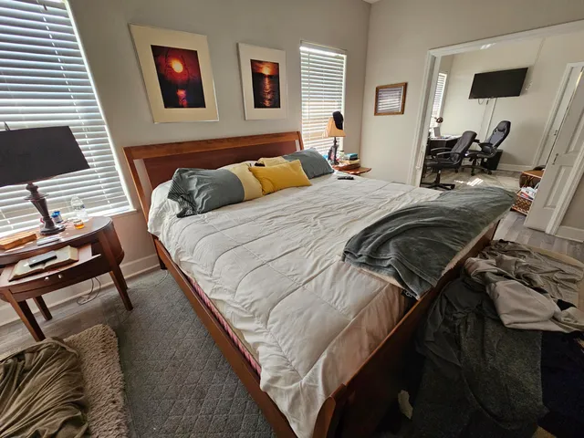 a bed sitting in a bedroom and view of living room