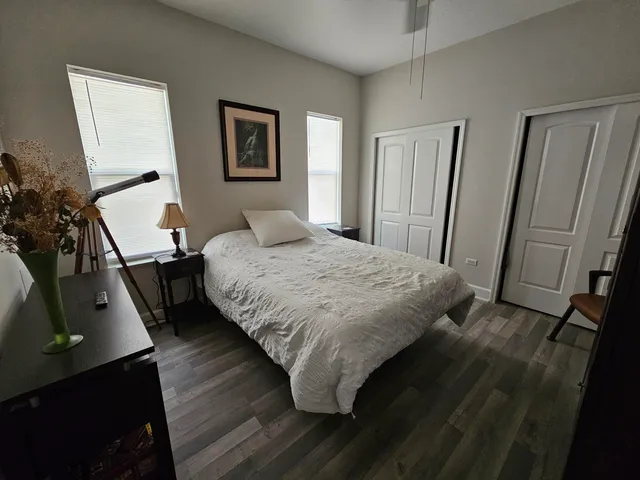 a bedroom with a bed and a flat tv screen on a dresser