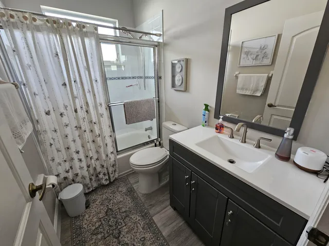a bathroom with a sink a toilet and shower