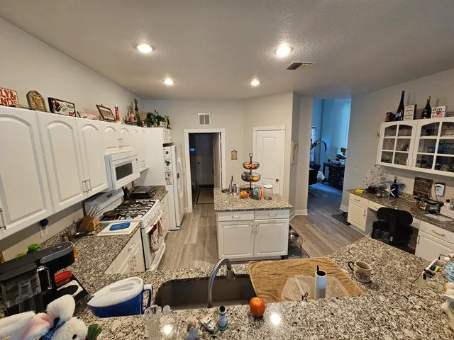 a large white kitchen with stainless steel appliances