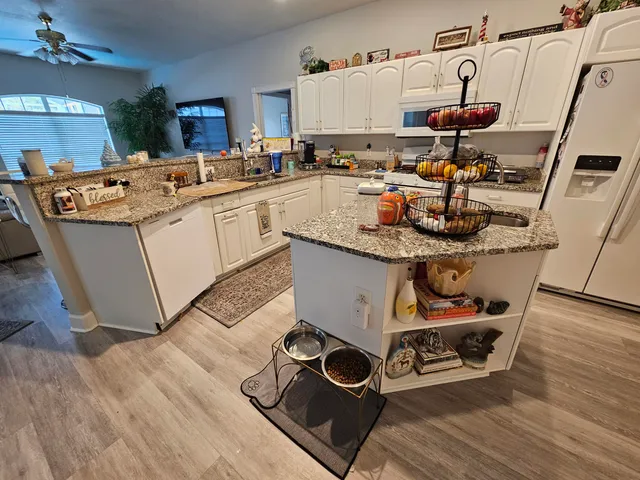 a room with appliances a sink and cabinets