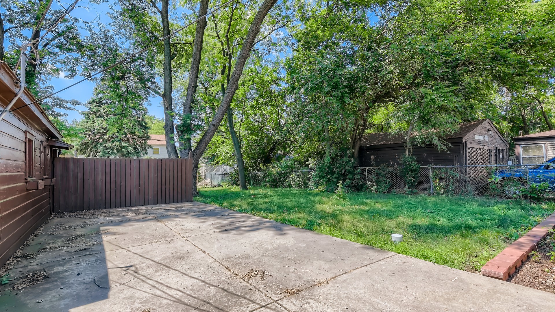 10718 South Pulaski Road Oak Lawn, IL 60453 - Photo 26 of 28 a view of a backyard with large trees and wooden fence